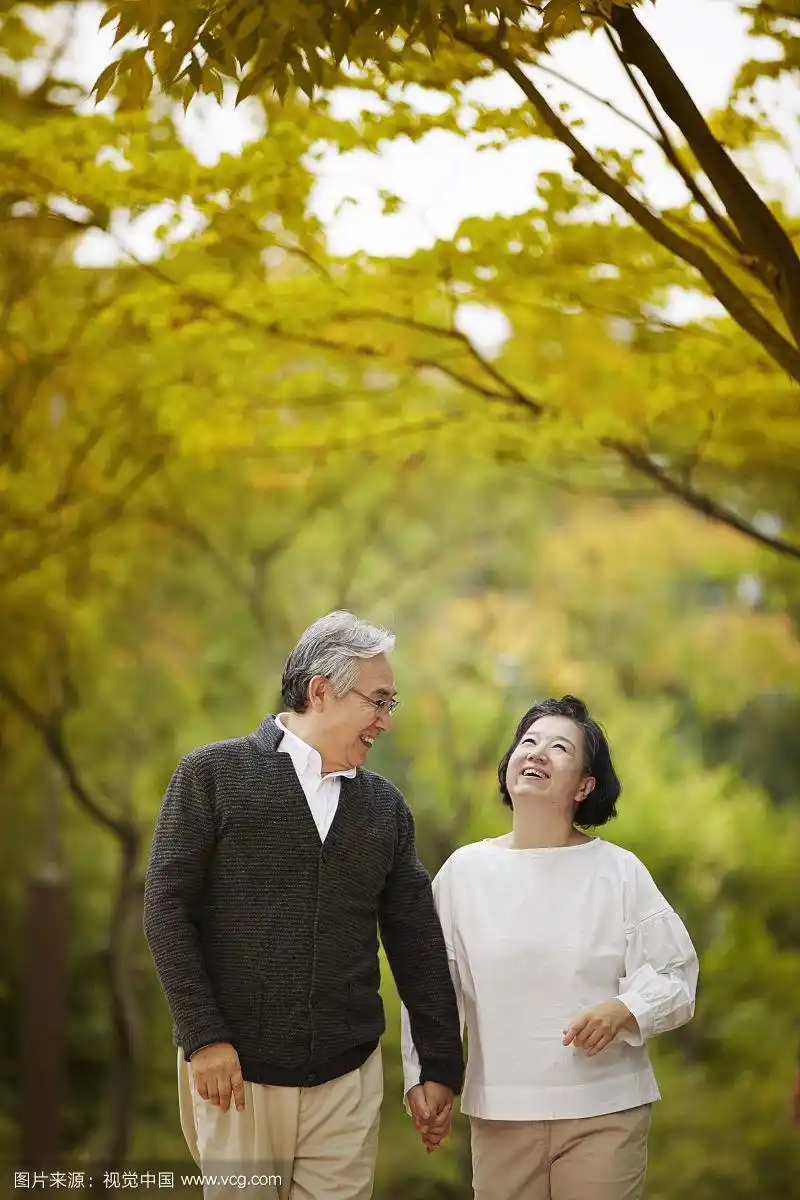 老年情侣在公园散步的照片