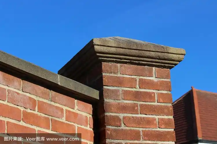 红砖方形门柱与铸石墩帽的图像