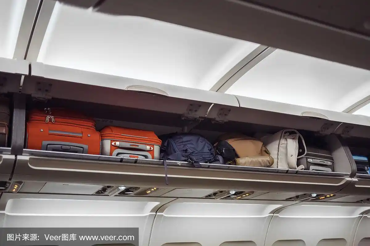飞机上的行李架和行李.飞机内部.旅游的概念
