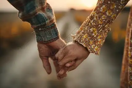 夕阳海边老人老年夫妇在托斯卡纳黄昏时分牵手散步背景