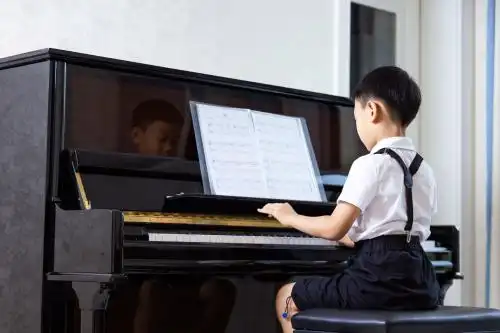 亚洲中国男孩认真地练习弹钢琴