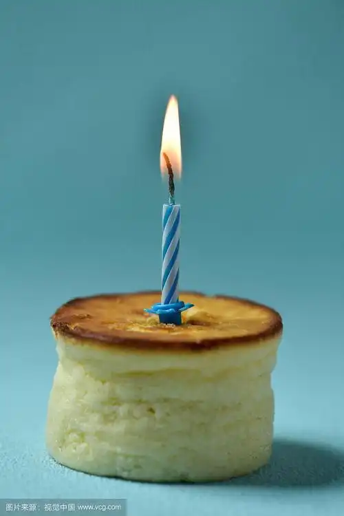 在芝士蛋糕上点燃生日蜡烛