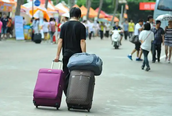 海南师范大学龙昆南校园内,一名新生拖着行李(南海网记者 秦彦 摄)