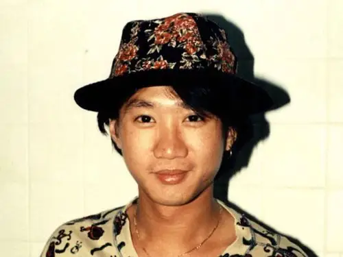 找一张黄家驹的照片,帽子和衣服有花,帽子是黑色,衣服是白色.