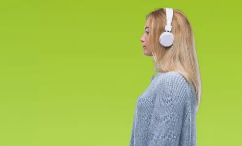 戴着耳机,在孤立的背景下,看着侧面放松的轮廓,自然的脸,自信的微笑