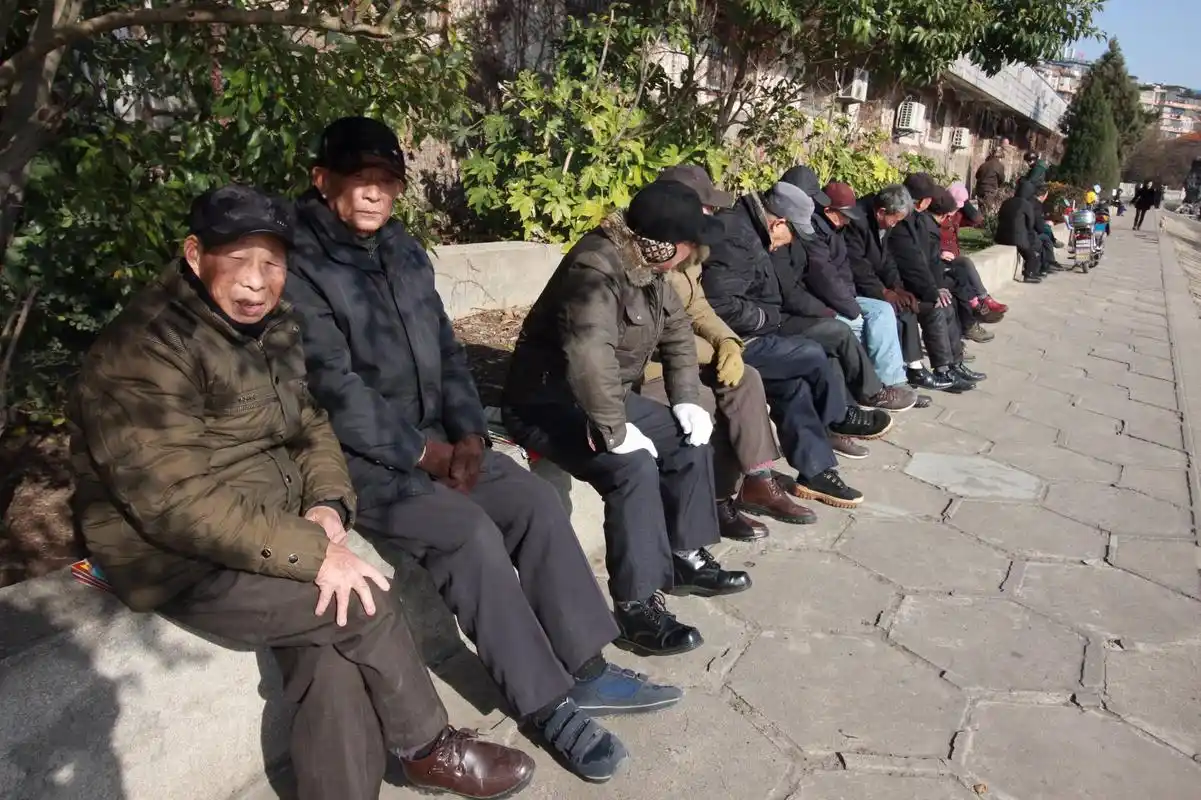 老人江堤边晒太阳排排坐如人墙