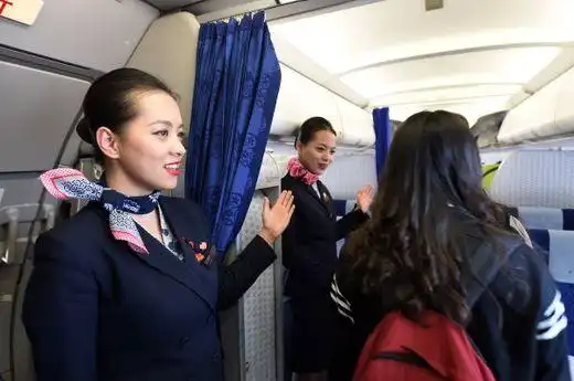 资料图片:空姐在机舱门口迎接旅客登机.新华社记者 范培珅 摄
