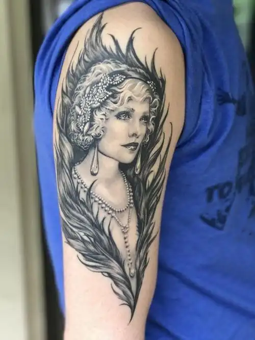 男生手臂上黑色点刺抽象线条羽毛和人物肖像纹身图案