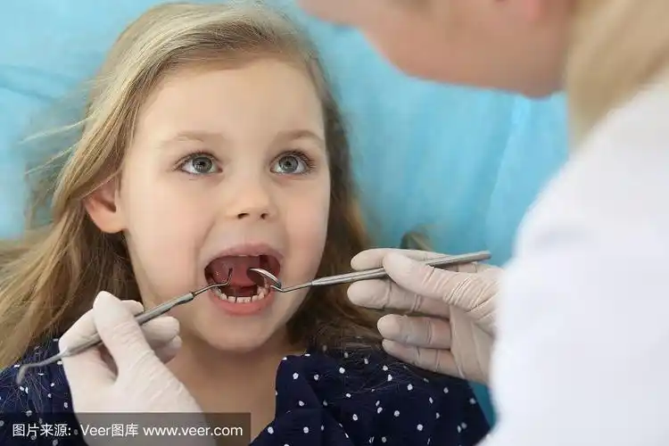 小女孩在接受医生的口腔检查时,张着嘴坐在牙科椅上,感到恐惧.