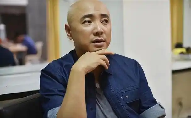 晒出了一张导演徐峥参加某现场活动的照片,镜头中,徐峥穿着一件红色毛