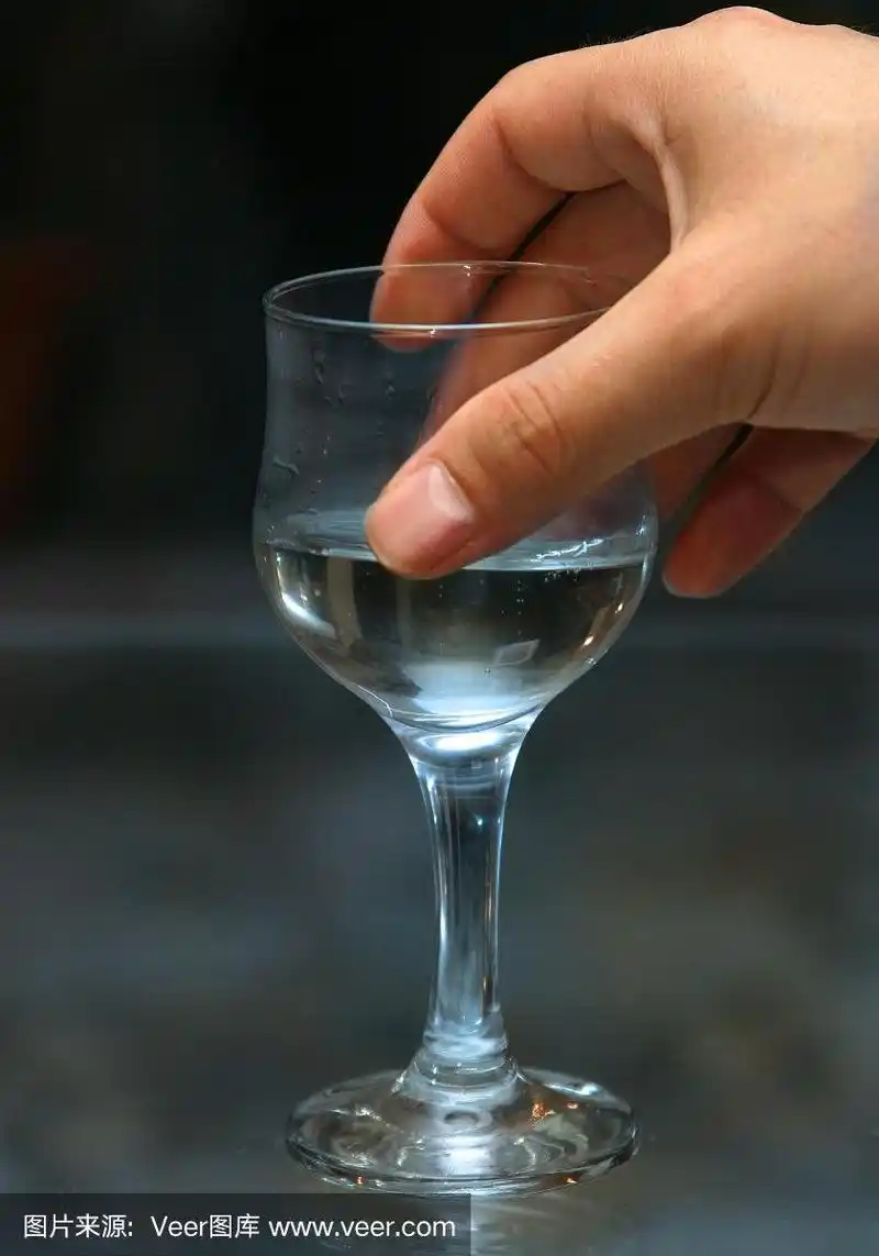 一个男人手里拿着酒精的杯子