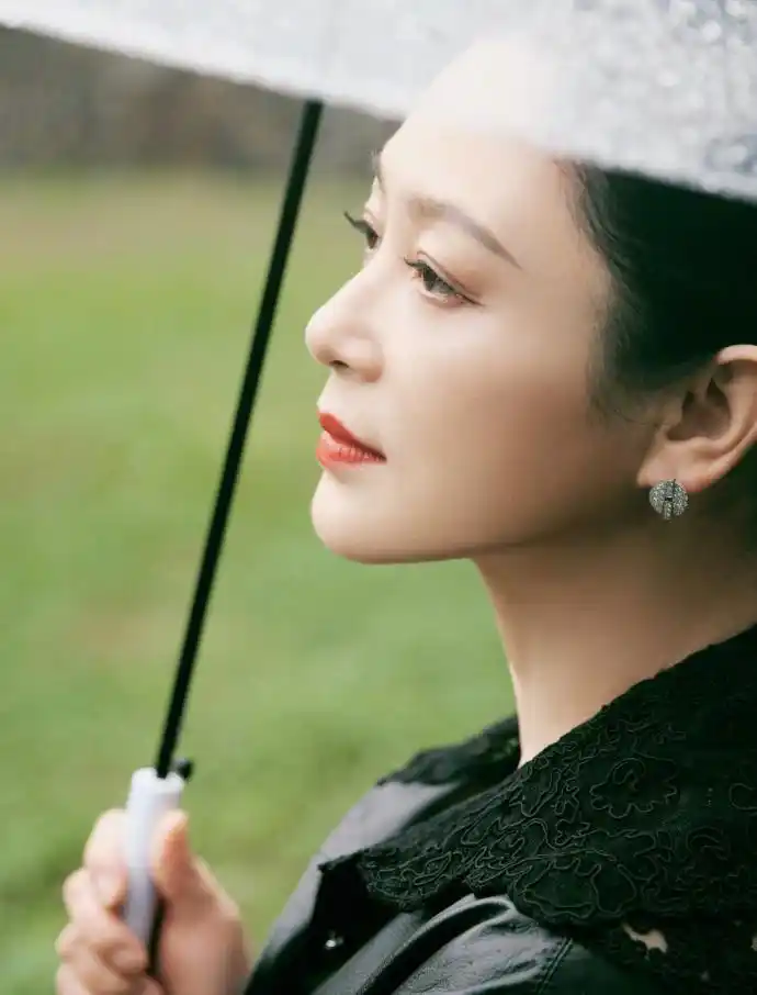 陈红穿黑色皮衣造型酷飒十足雨中撑伞漫步气质惊艳