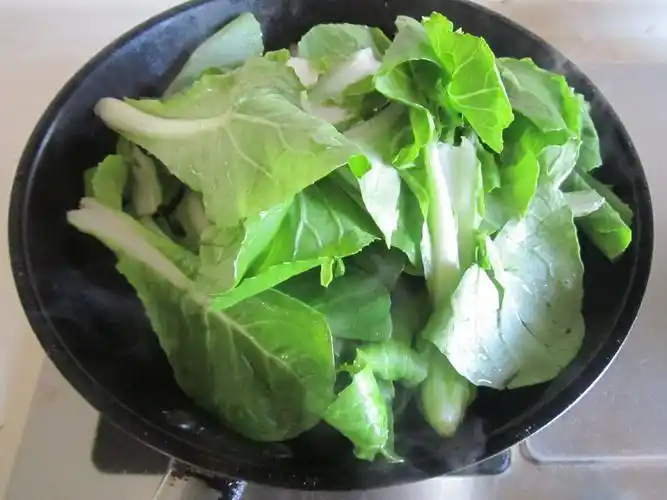 3. 再加入大白菜秧进去翻炒;4. 微微变色时加入1勺糖翻炒均匀;5.