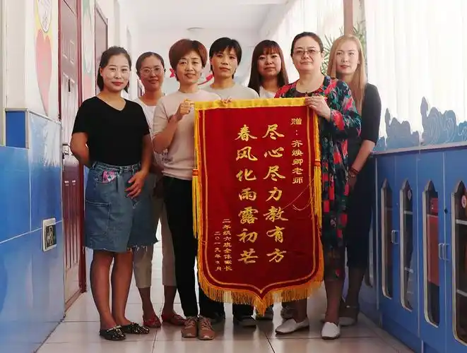 家长们把锦旗送到李娜新校长(左三)和齐焕卿老师(右二)手中