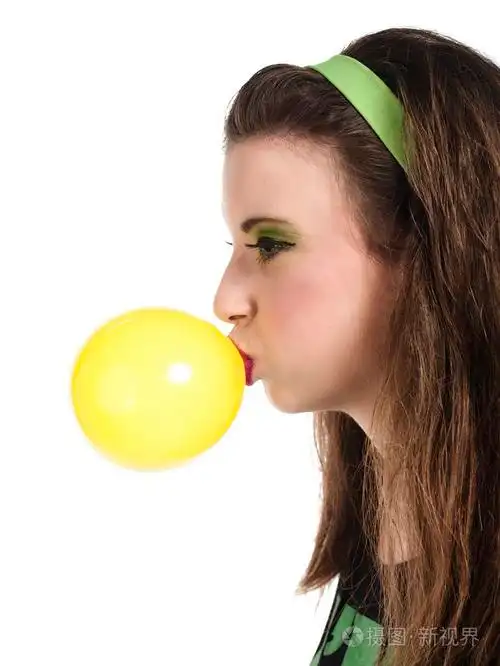 一名年轻女子吹泡泡糖的侧视图