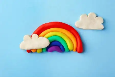 彩色背景彩云的可塑彩虹橡皮泥学校用品和彩色背景上的校徽在白色背景