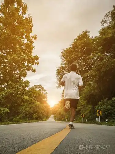 日落时,年轻人在乡村公路旁奔跑.