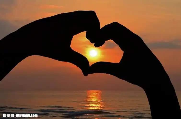 夕阳与爱心手势图