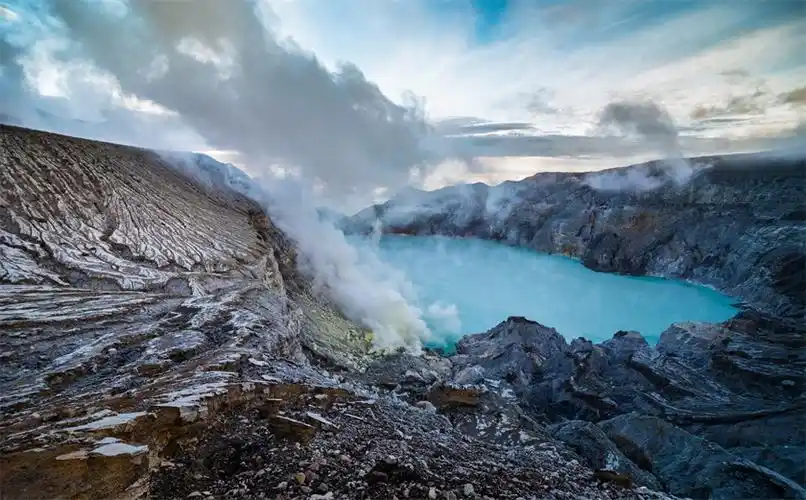 摄影师在印尼的蓝色火山上为新人拍摄婚纱照