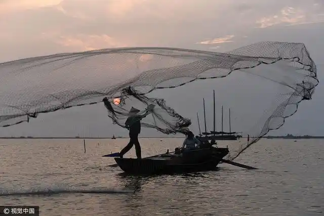 渔民在洪泽湖上撒网捕鱼.  图片来源:贺敬华/视觉中国