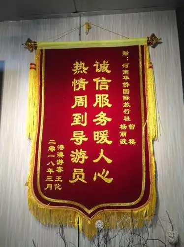 一副"诚信服务暖人心 热情周到导游员"署名"港澳游客王女士"的锦旗