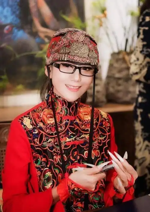 61岁杨丽萍近照曝光,穿东北大花裙在花园摆拍,3cm长指甲太吸睛