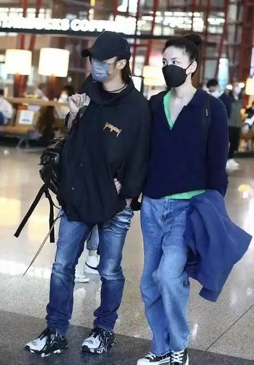 王菲牵谢霆锋走机场扎马尾像高中生小男友单手插兜扮酷