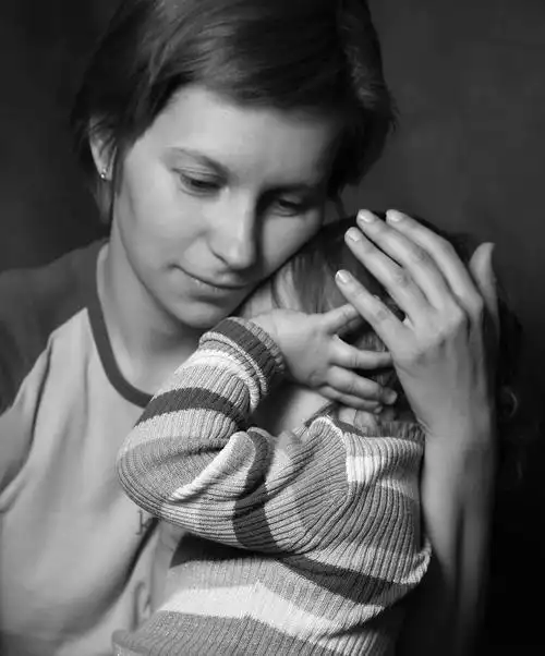 柔情母亲轻轻地拥抱啼哭的孩子