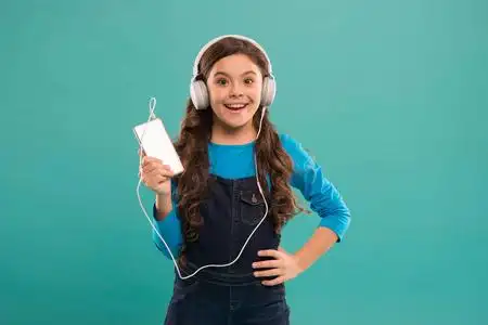 享受完美的声音.女孩听音乐现代耳机和智能手机.免费收听照片