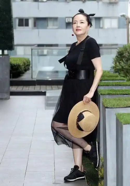 照片中,恬妞穿了一件白色西装外套内搭红色抹身材时尚衫,头上绑着一个