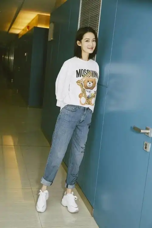 李沁身穿小熊白色卫衣搭牛仔裤清新可人,发丝微乱尽显率性甜美