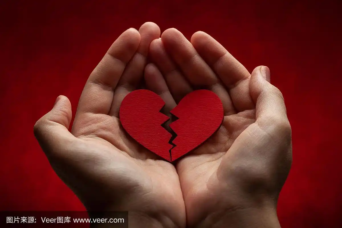 女人手里握着破碎的心.裂痕在红心,破裂的关系