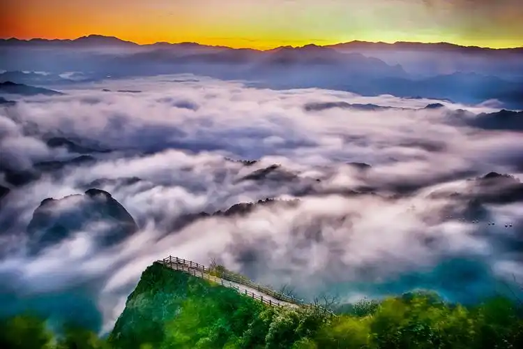 阳光下,座座殷红色丹霞石峰在云雾中若隐若现,把景区装扮得如同仙境.