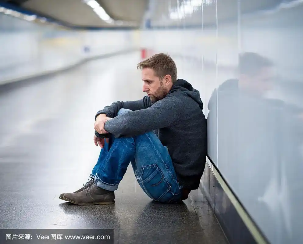 悲伤的年轻人哭着遭受抑郁压力坐在地面街道地铁隧道看起来绝望独自靠
