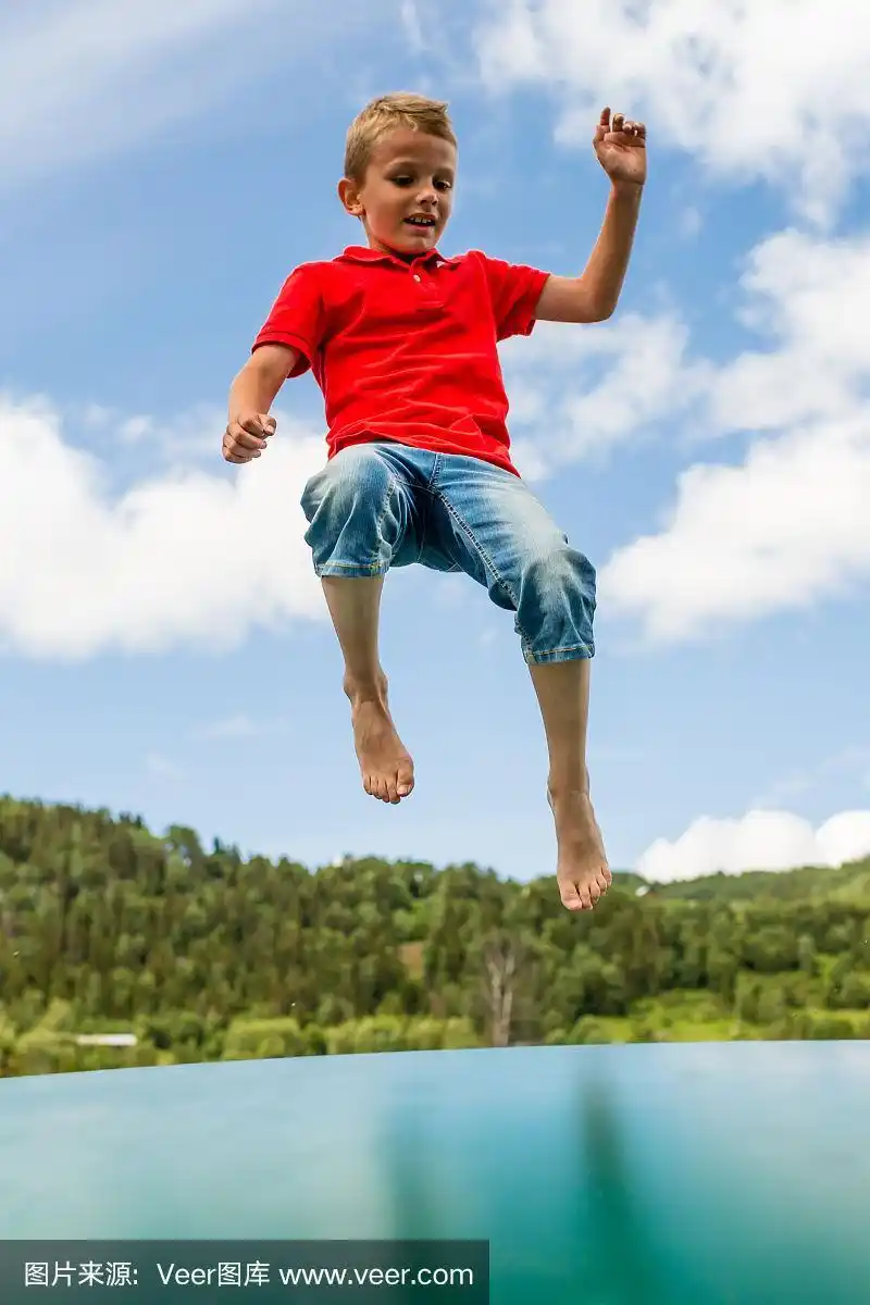 小男孩在蹦床上跳