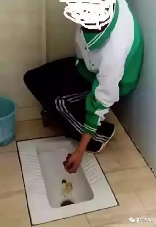 在时长1分33秒的视频中,身穿绿白两色校服的男生站在厕所蹲坑后侧,在