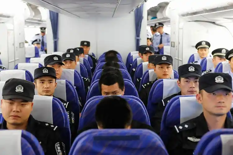 在菲律宾马尼拉国际机场,涉案人员由押解人员押解,准备乘坐飞机回国