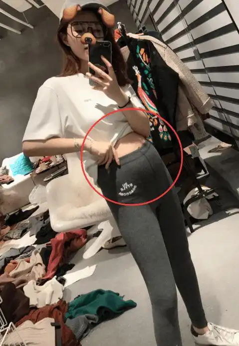 雪梨挺着大肚子,左手拿着手机自拍,右手撩起白色上衣,圆鼓鼓的大肚子