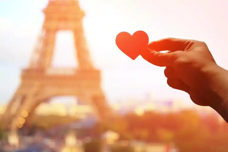 浪漫情侣手持有爱的心纸与埃菲尔铁塔在巴黎与夕阳的剪影幸福情侣幸福
