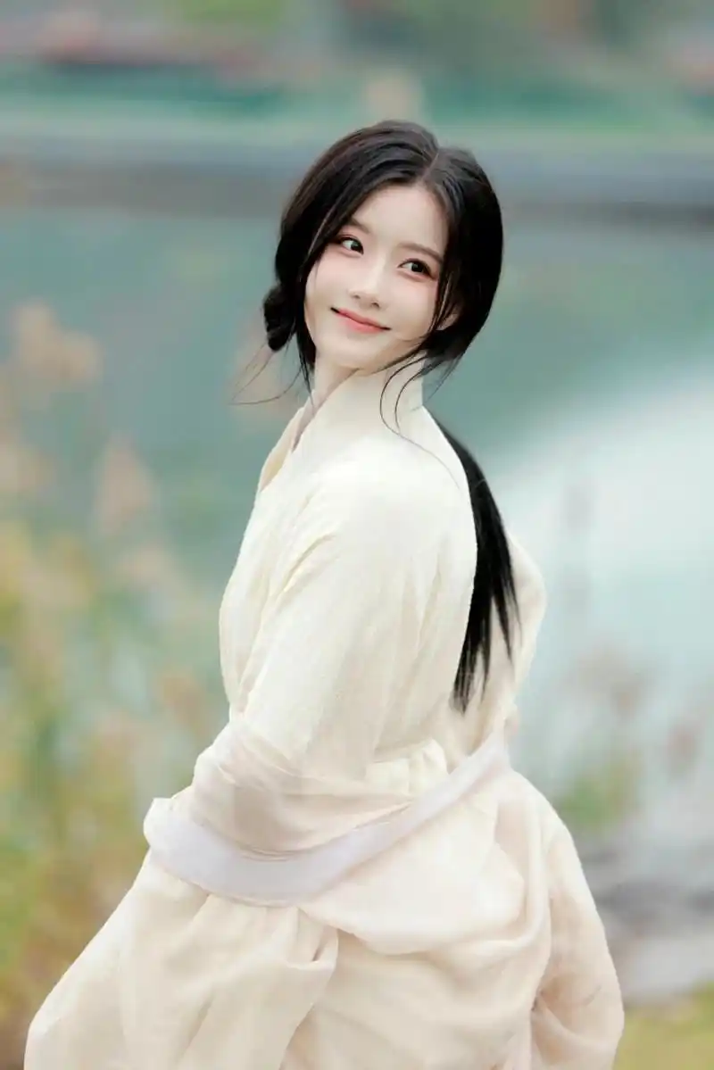 白衣古装美女手持古伞,徜徉湖畔.