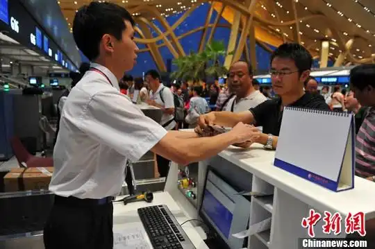 图为首批在长水机场登机的旅客在办理登机手续.中新社发 任东 摄