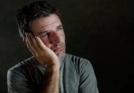 的黑暗背景肖像,30到40岁的悲伤和沮丧的人,看上去体贴和担心的痛苦