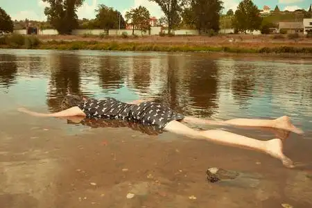 穿黑色衣服的妇女在城市夏河岸附近被淹死照片