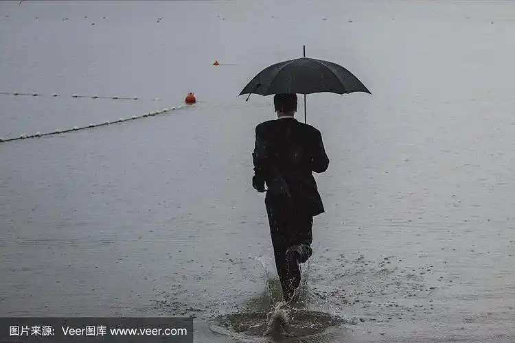 帅气的男人穿着西装,在雨中撑着伞