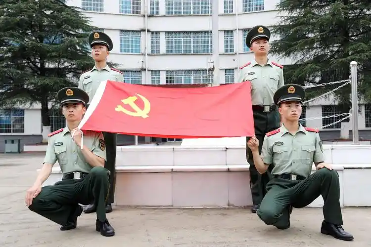 礼兵擎举着鲜红夺目的党旗,象征着工农联盟的金色镰刀锤子图案在